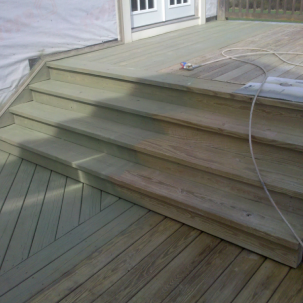 Newly built wooden deck stairs attached to a house