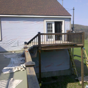 Elevated wooden deck under renovation with railings and support beams